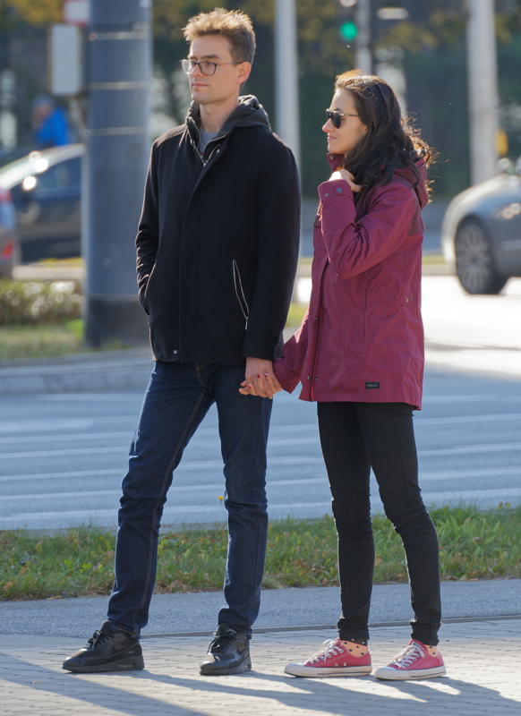20 - A young couple holding hands while out for a stroll on a chilly day